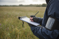 Surveyor's arm wearing waterproof field notebook armband in a field